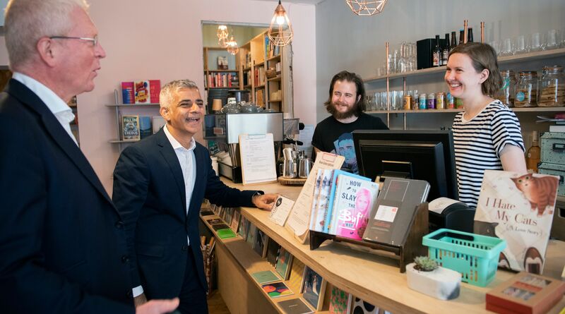 Sadiq laughs with local shopkeepers.