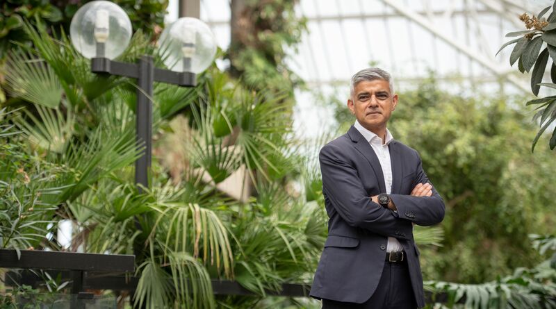 Sadiq stands, arms crossed, facing the camera at the launch of an environment campaign. He's surrounded by lush greenery.