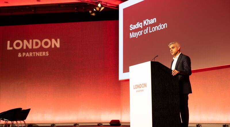 Sadiq stands at a podium making a speech.