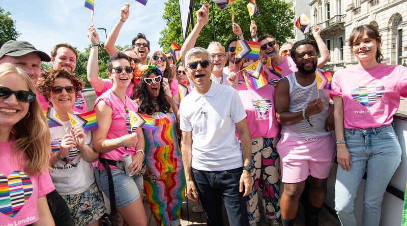 Sadiq stands with a group of LGBTQ+ Londoners. Everyone is wearing a combination of pink and white.