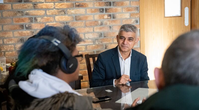 Sadiq speaks to a Londoner across the table from him.